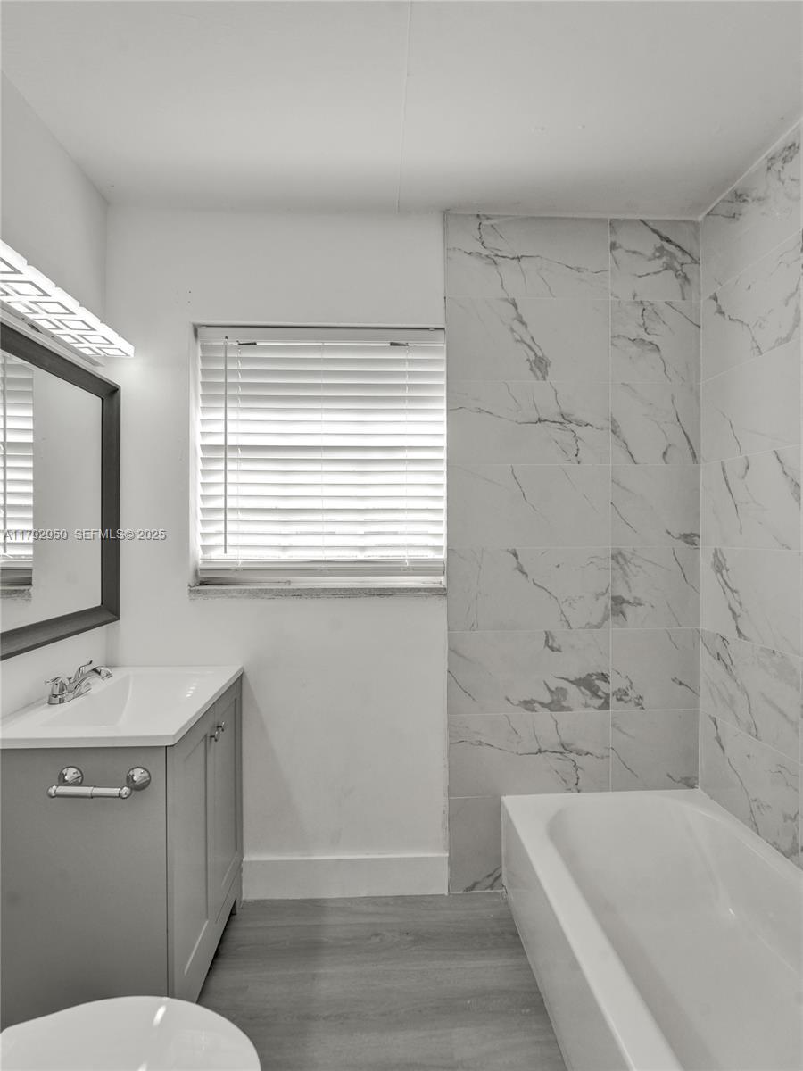 5657 Grant Street Hollywood, FL 33021 - Photo 39 of 59 a bathroom with a sink a toilet a mirror and bathtub