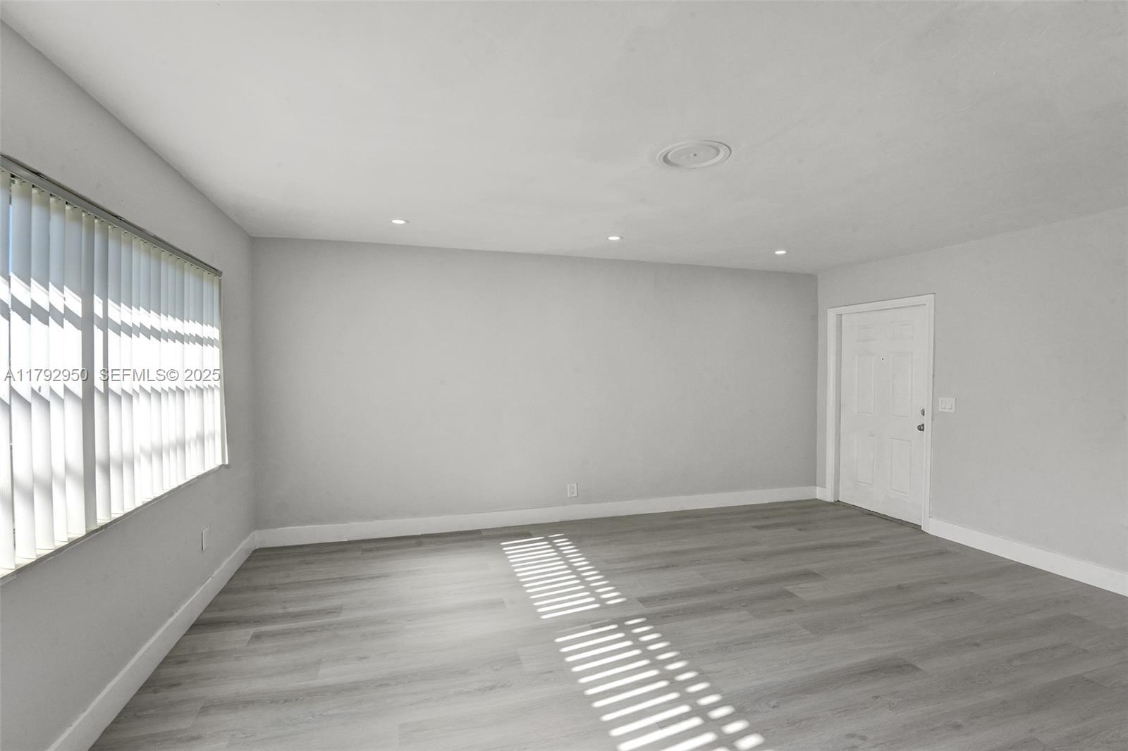 5657 Grant Street Hollywood, FL 33021 - Photo 9 of 59 wooden floor in an empty room with a window