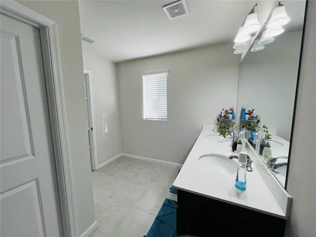 a spacious bathroom with a shower sink and a mirror