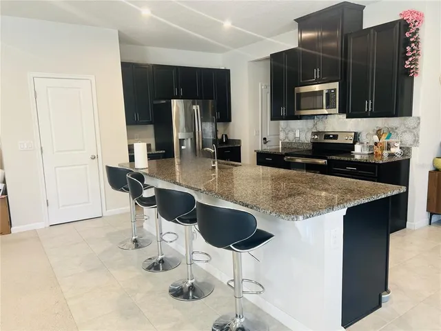 a kitchen with stainless steel appliances granite countertop a sink and a microwave