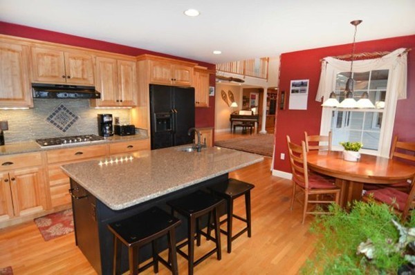 47 Whitcomb Road Boxborough, MA 01719 - Photo 3 of 29 a kitchen with stainless steel appliances kitchen island granite countertop a table chairs in it and wooden floors