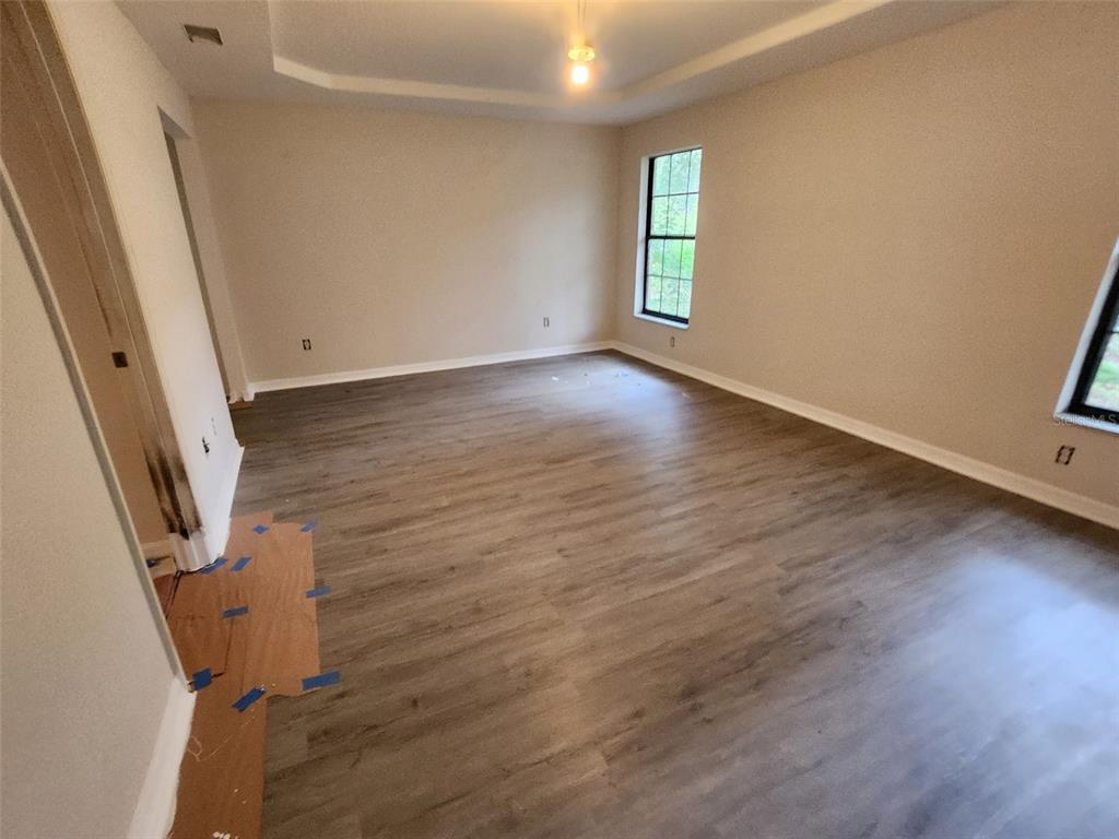 13767 Northeast 47th Avenue Anthony, FL 32617 - Photo 5 of 7 an empty room with wooden floor and windows