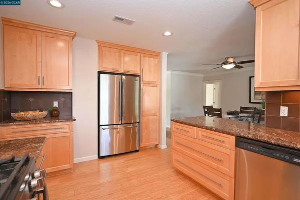 a kitchen with granite countertop a refrigerator stove and sink