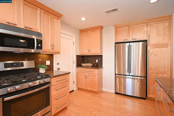 a kitchen with stainless steel appliances granite countertop a refrigerator stove and microwave