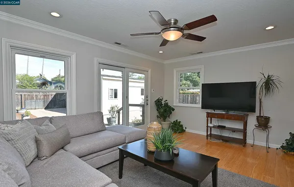 a living room with furniture and a flat screen tv with wooden floor