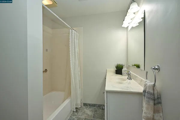a bathroom with a granite countertop sink and a mirror