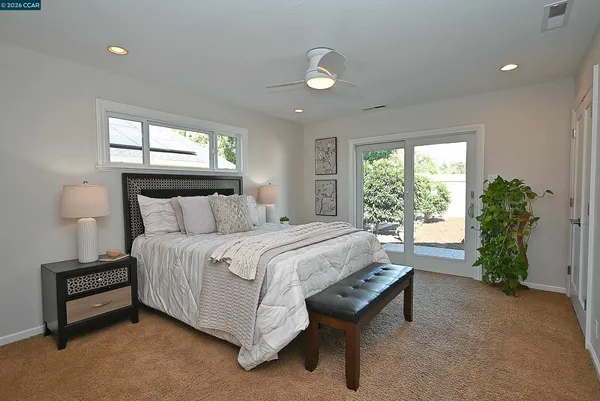 a bed sitting in a spacious bedroom next to a window