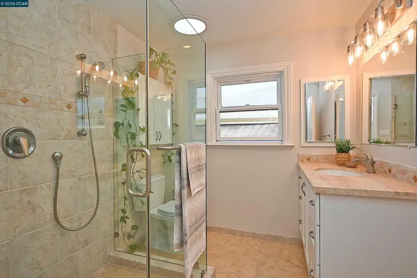 a bathroom with a double vanity sink mirror and shower