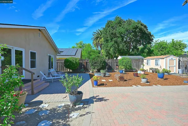 a view of a house with backyard sitting area and garden