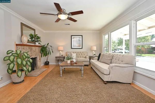 a living room with furniture ceiling fan and a window