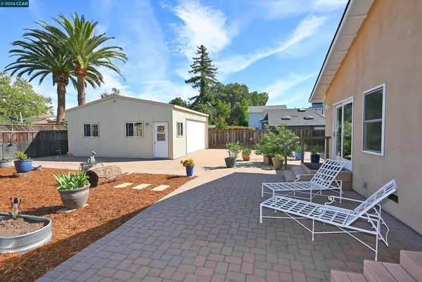 a view of a house with backyard and sitting area
