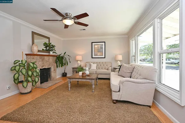 a living room with furniture a fireplace and a large window
