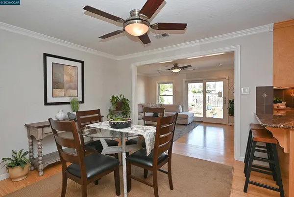 a view of a dining room with furniture a chandelier and wooden floor