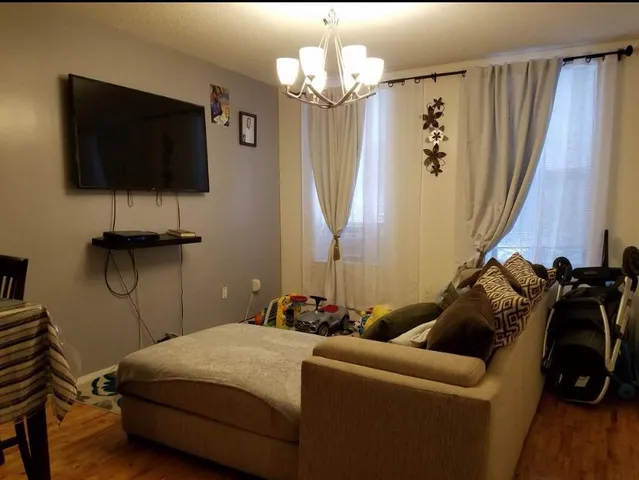 a bedroom with a bed a flat screen tv and a bookshelf