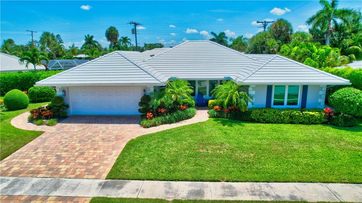 1163 Mulberry Way Boca Raton, FL 33486 - Photo 1 of 66 a front view of a house with a garden