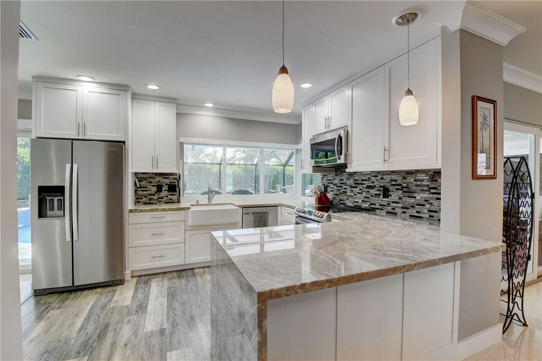 1163 Mulberry Way Boca Raton, FL 33486 - Photo 42 of 66 a kitchen with stainless steel appliances granite countertop a sink a stove and a refrigerator