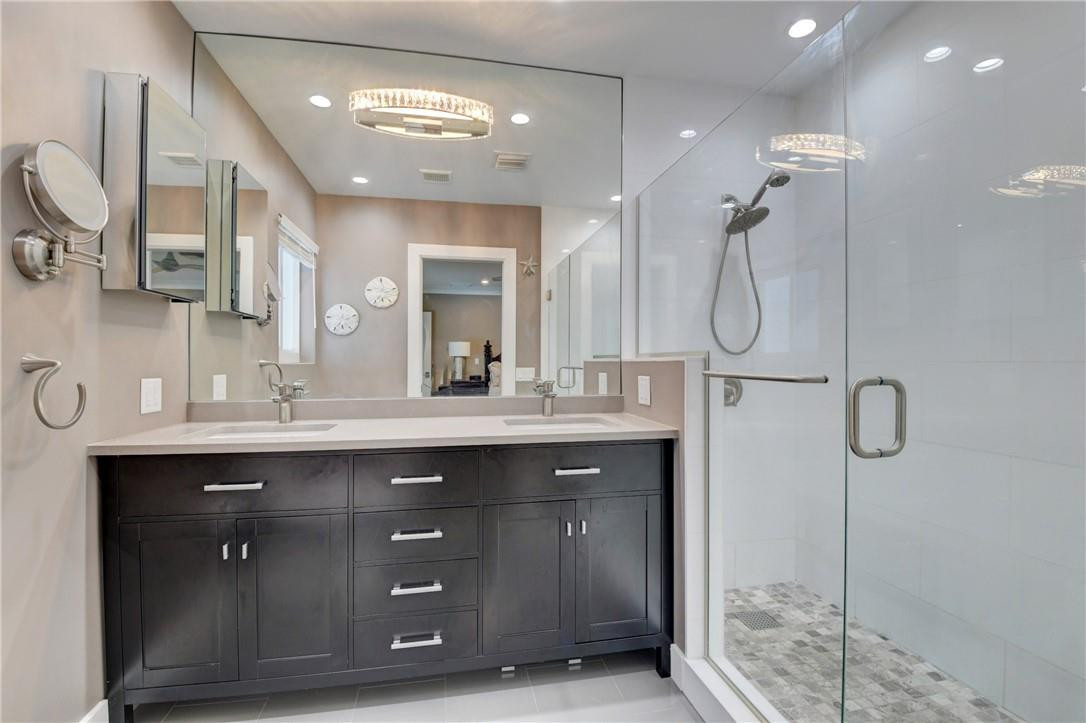 1163 Mulberry Way Boca Raton, FL 33486 - Photo 57 of 66 a bathroom with a double vanity sink a toilet a mirror and shower