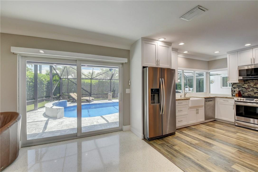 1163 Mulberry Way Boca Raton, FL 33486 - Photo 59 of 66 a kitchen with a refrigerator and white cabinets