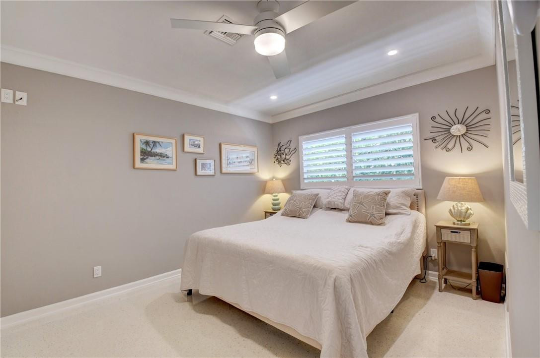 1163 Mulberry Way Boca Raton, FL 33486 - Photo 61 of 66 a bedroom with a bed and a chandelier