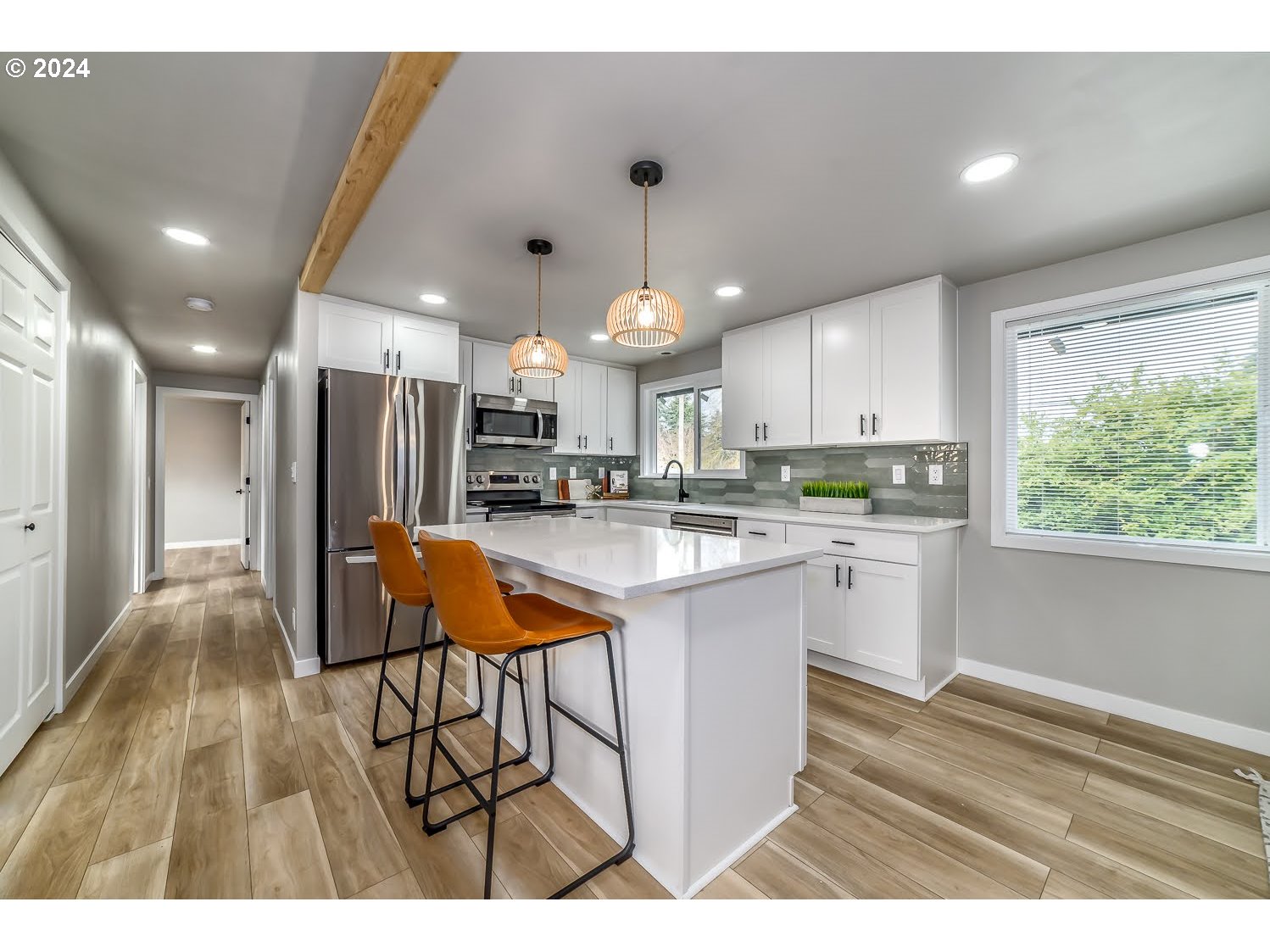 375 Heritage Avenue Eugene, OR 97404 - Photo 8 of 32 a kitchen with stainless steel appliances kitchen island granite countertop a refrigerator a sink dishwasher a stove and white cabinets with wooden floor