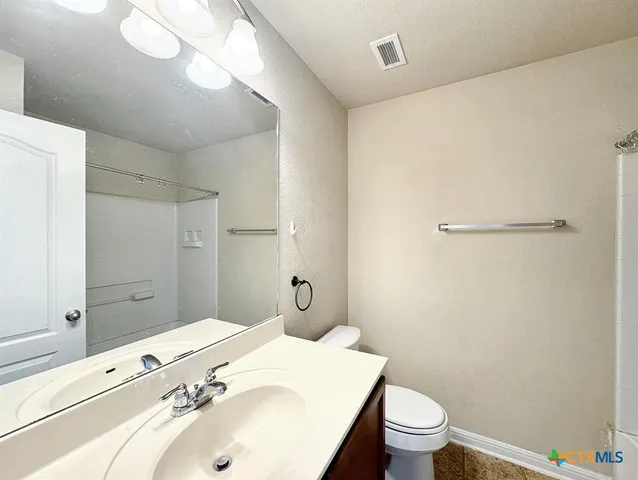 a bathroom with a sink and mirror with toilet