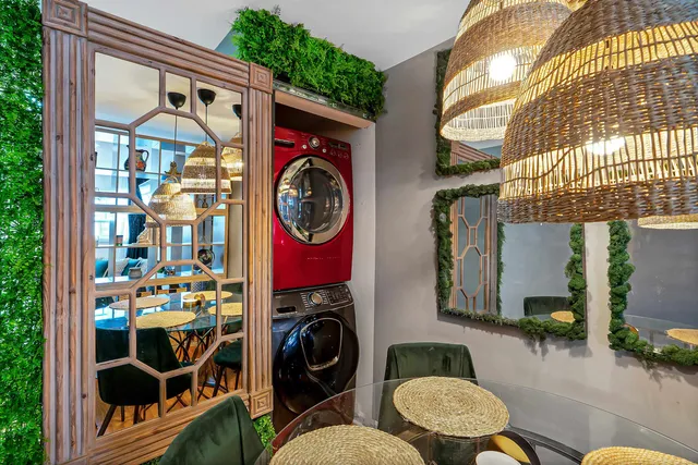 a front view of a house with outdoor seating and lots of windows