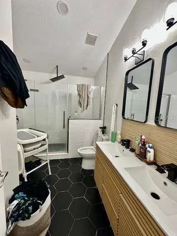 a bathroom with a sink a toilet and shower