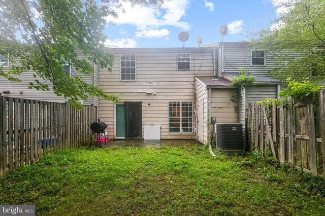 a view of a house with backyard and wooden fence