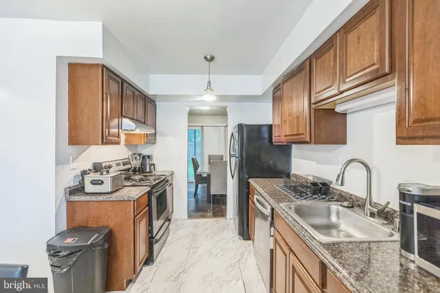 a kitchen with stainless steel appliances granite countertop a sink stove and refrigerator
