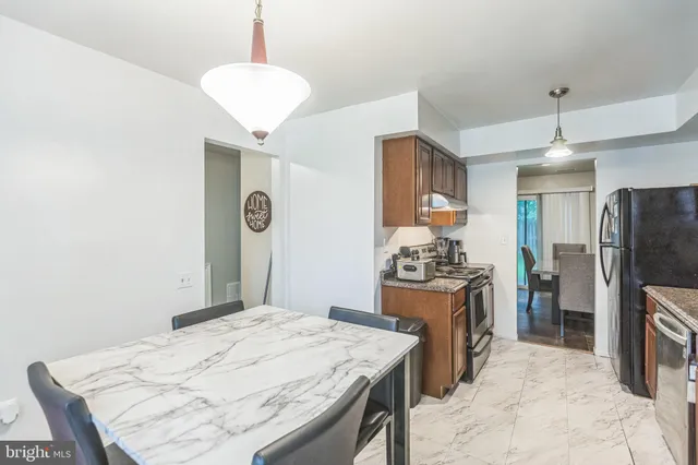 a kitchen with stainless steel appliances granite countertop a stove refrigerator and a sink