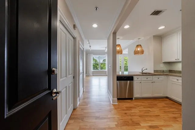 a view of a kitchen with a sink and dishwasher a refrigerator with wooden floor