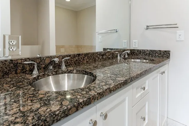 a bathroom with a granite countertop sink and a mirror