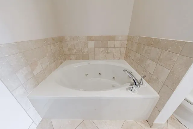 a white bath tub sitting in a bathroom and shower
