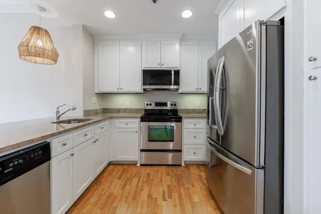 a kitchen with a refrigerator and a stove top oven
