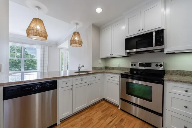 a kitchen with stainless steel appliances granite countertop a sink and a microwave