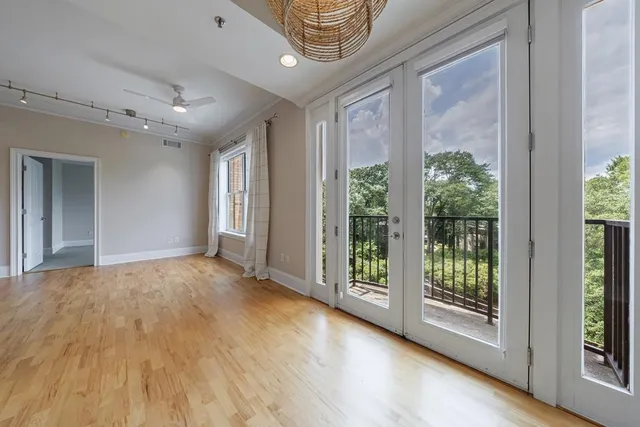 a view of an empty room with glass door and balcony