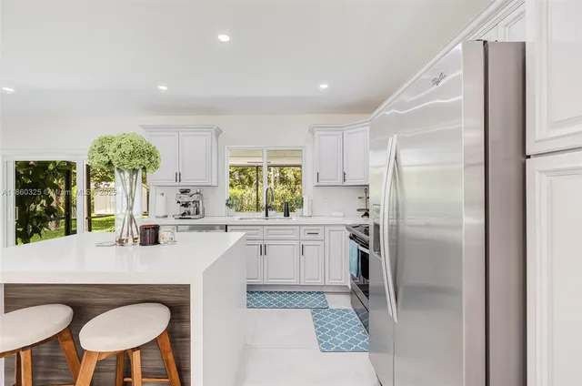 a kitchen with refrigerator and chairs