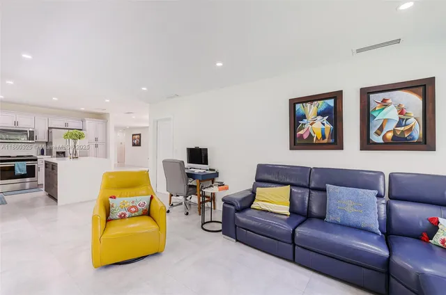 a living room with furniture gym equipment and kitchen view