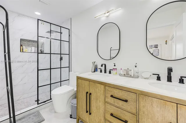 a bathroom with a sink a toilet and a mirror