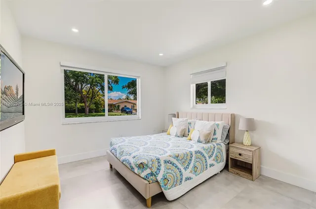 a bedroom with a bed and painting on the wall