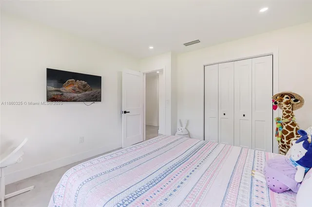 a bedroom with a bed and a painting on the wall