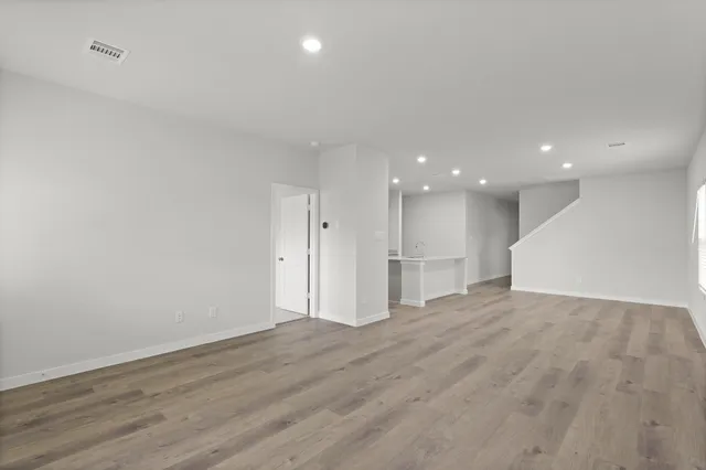 a view of an empty room with wooden floor