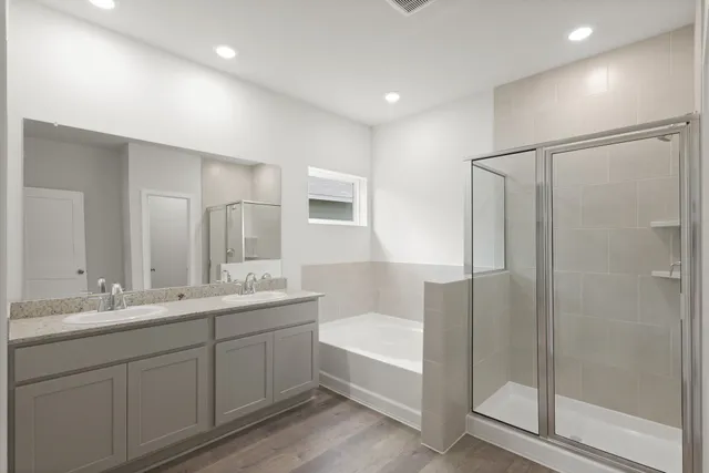 a bathroom with a double vanity sink mirror and shower