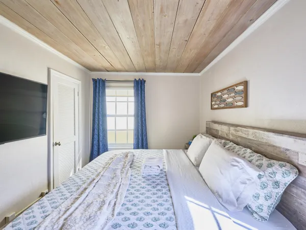a bedroom with a large bed and a chandelier