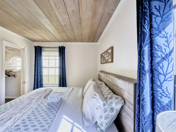a bed sitting in a bedroom next to a window and a chandelier