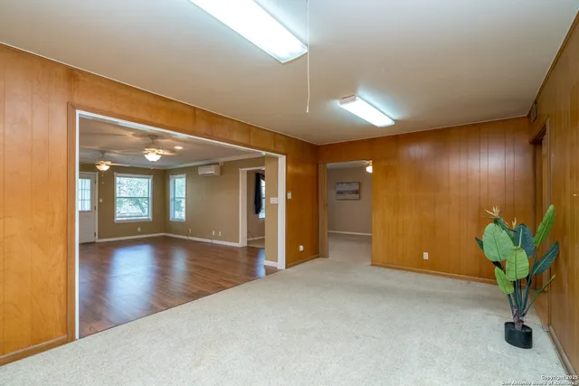 an empty room with windows and fan