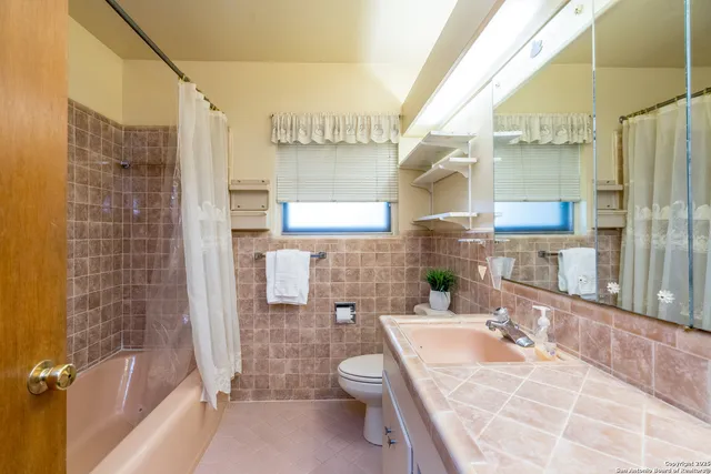 a bathroom with a tub a sink and a large mirror