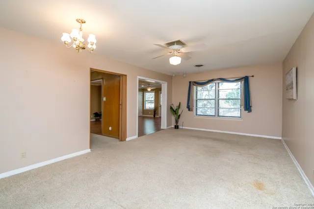 an empty room with windows and chandelier