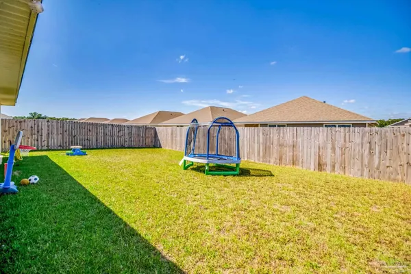 a view of yard with swimming pool and trees in the background