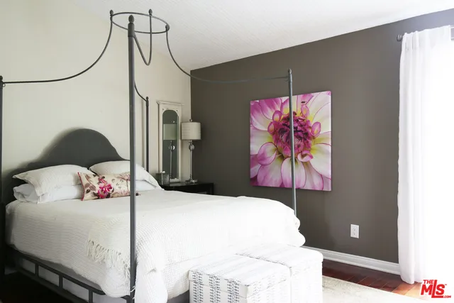 a bedroom with a bed and a painting on the wall